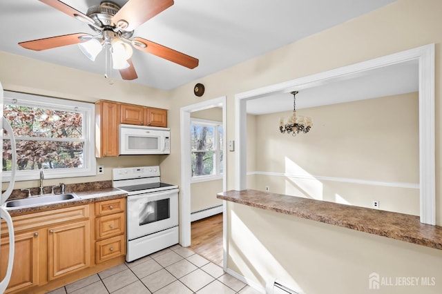 kitchen featuring light tile patterned floors, a baseboard heating unit, white appliances, a sink, and pendant lighting