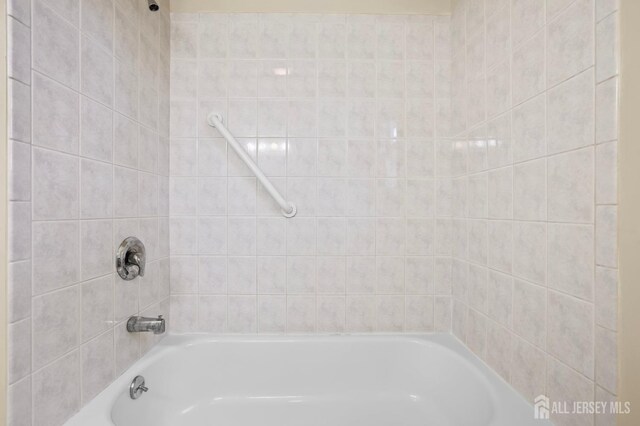 bathroom featuring tiled shower / bath