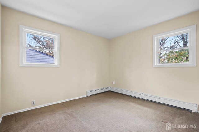 spare room with baseboard heating and carpet