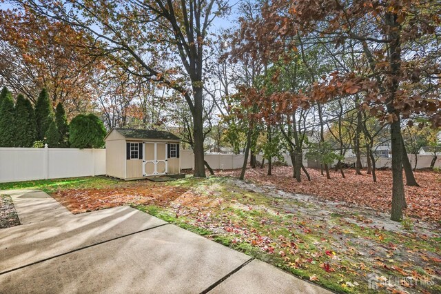 view of yard featuring a storage shed and a patio