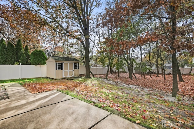 view of yard featuring an outbuilding, a fenced backyard, a patio, and a storage shed