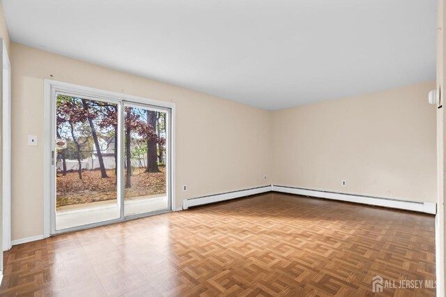 unfurnished room with baseboard heating and parquet flooring