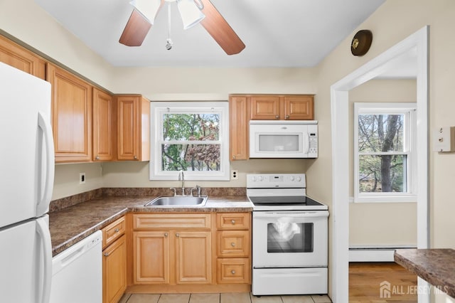 kitchen with ceiling fan, a baseboard heating unit, white appliances, a sink, and dark countertops