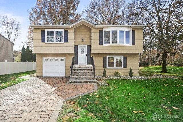 bi-level home featuring a garage and a front yard