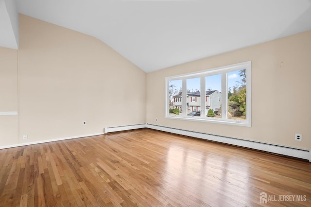 unfurnished room featuring vaulted ceiling, a baseboard heating unit, baseboard heating, and wood finished floors