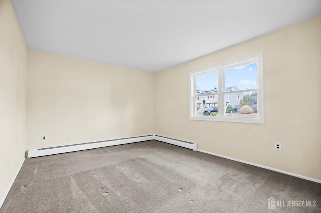 spare room featuring carpet flooring and baseboards