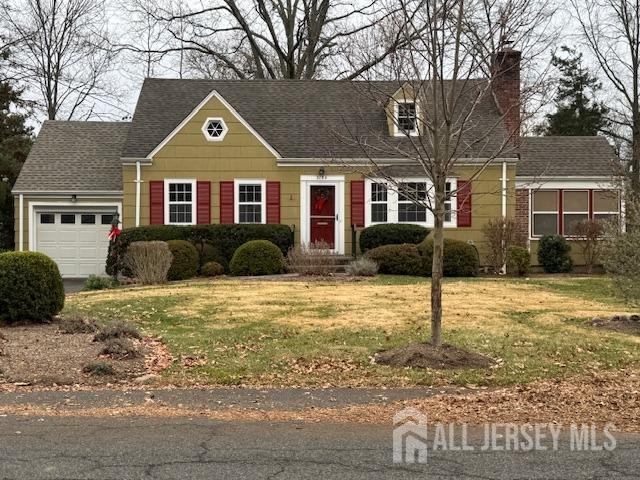 new england style home with a front lawn and a garage