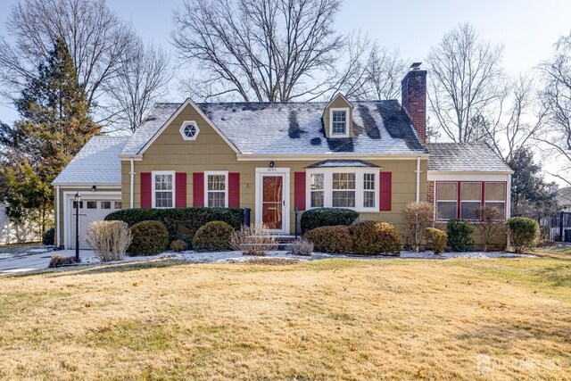 cape cod-style house with a garage and a front lawn