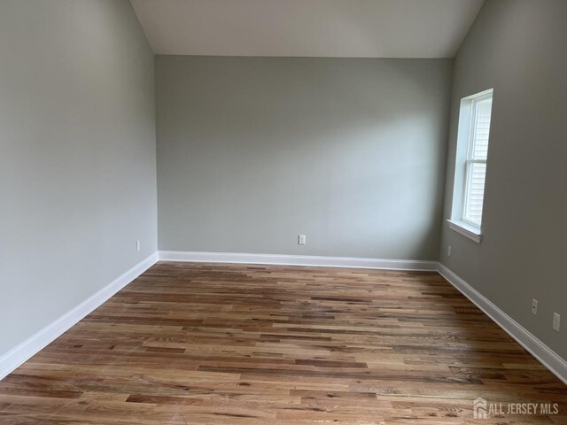 21 Catherine St, Carteret, NJ 07008 - spare room with lofted ceiling, wood finished floors, and baseboards