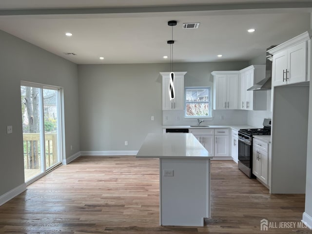 21 Catherine St, Carteret, NJ 07008 - kitchen featuring stainless steel range with gas cooktop, a sink, visible vents, baseboards, and wall chimney exhaust hood
