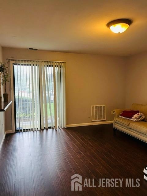 unfurnished bedroom featuring dark wood-style floors, baseboards, and visible vents