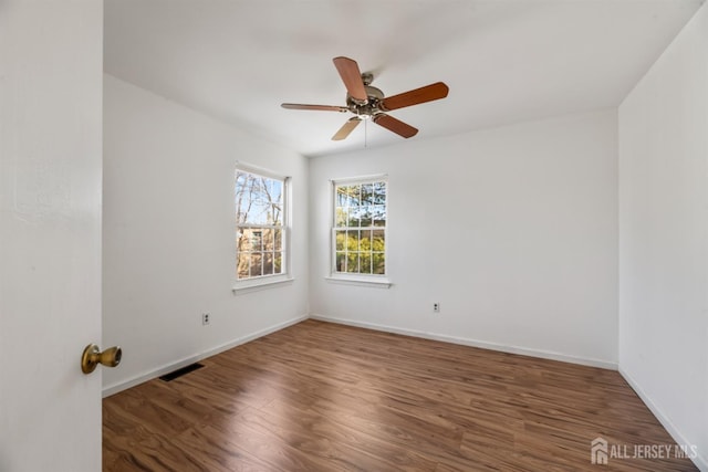 unfurnished room with ceiling fan and dark hardwood / wood-style floors