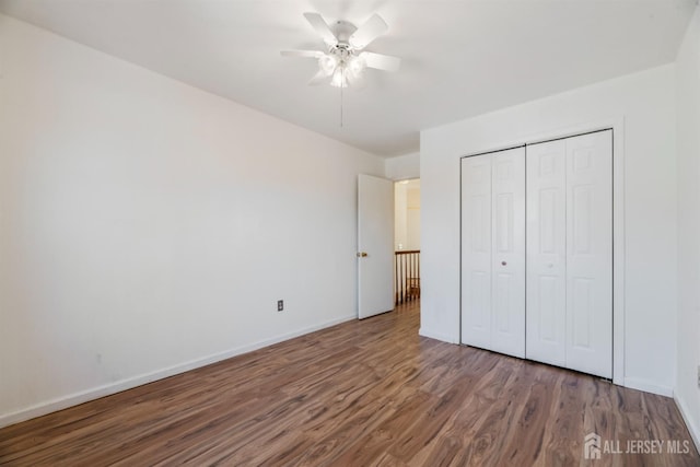 unfurnished bedroom featuring ceiling fan, wood-type flooring, and a closet