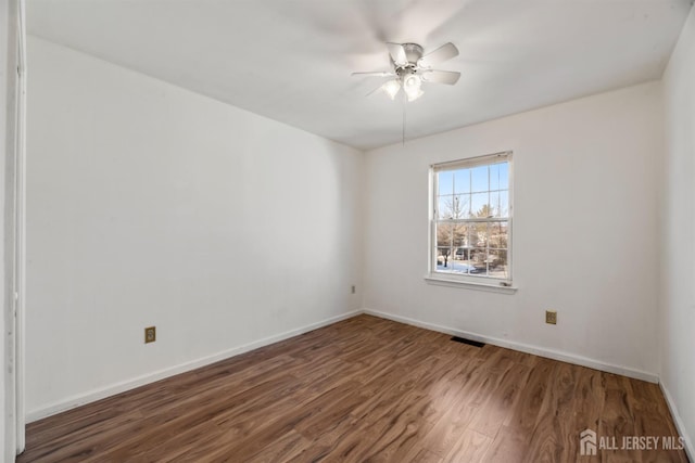 unfurnished room featuring ceiling fan and dark wood-type flooring