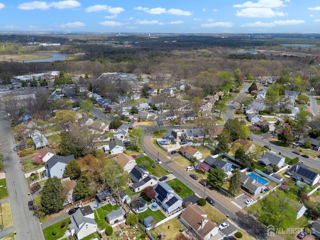 aerial view of property and surrounding area featuring nearby suburban area and a nearby body of water