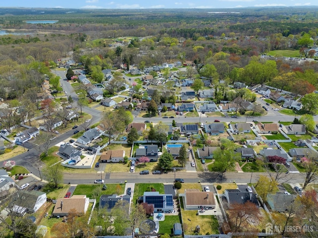 aerial view of property's location with a forest and nearby suburban area