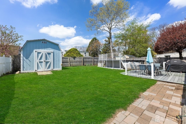 view of yard with a storage unit, an outbuilding, and a deck