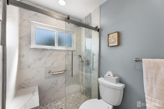 full bathroom featuring toilet and a marble finish shower