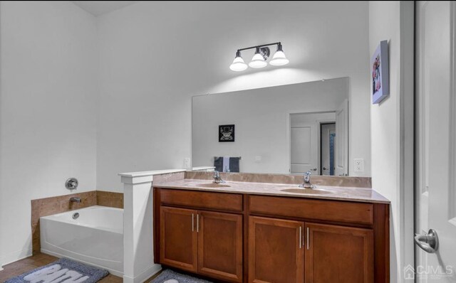 bathroom featuring tile patterned floors, vanity, and a tub to relax in