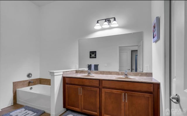 bathroom with a bath, double vanity, tile patterned flooring, and a sink