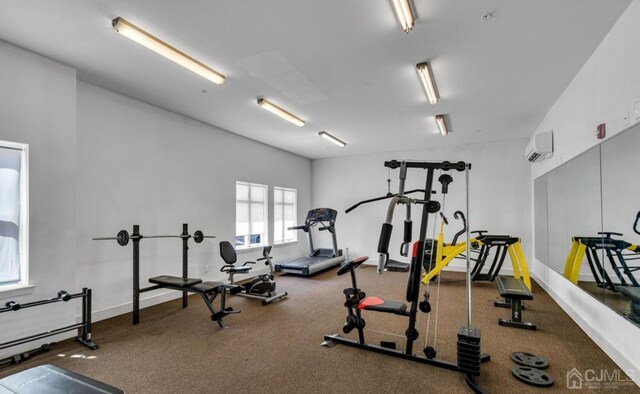 gym featuring baseboards and a wall mounted AC