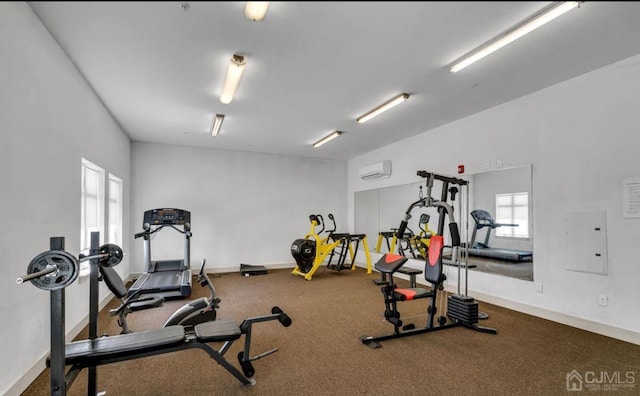 exercise area featuring electric panel, baseboards, and an AC wall unit