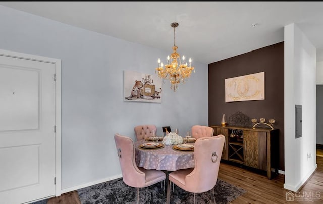 dining space with an inviting chandelier, wood finished floors, electric panel, and baseboards
