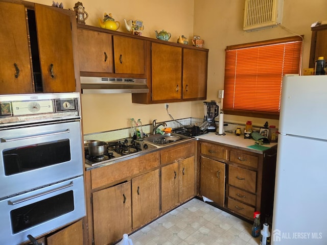 42 Hyde Ave, Iselin, NJ 08830 - kitchen with stainless steel appliances, under cabinet range hood, brown cabinetry, and a wall mounted air conditioner