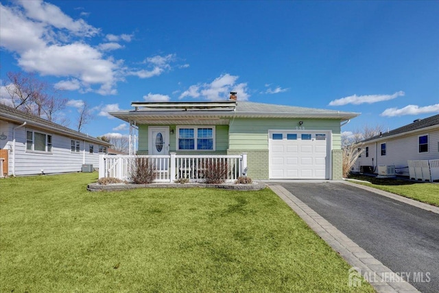 ranch-style home featuring brick siding, a front lawn, aphalt driveway, covered porch, and an attached garage