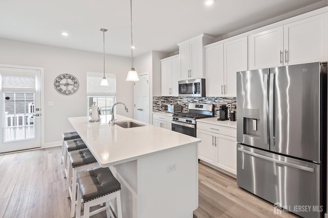 1915 Switzer Ave, Parlin, NJ 08859 - kitchen with appliances with stainless steel finishes, a sink, decorative backsplash, a breakfast bar, and a center island with sink
