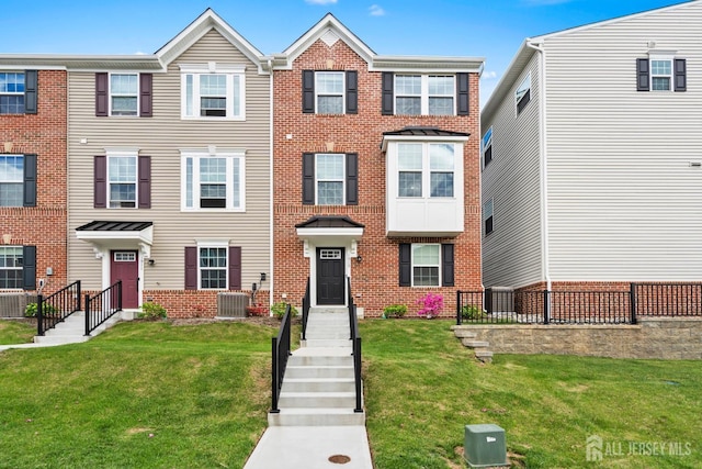 1915 Switzer Ave, Parlin, NJ 08859 - view of property with brick siding, central air condition unit, and a front lawn