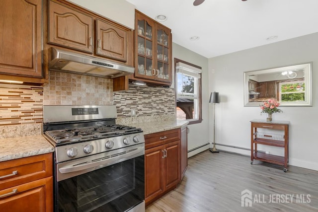 124 6th Ave, Middlesex, NJ 08846 - kitchen featuring under cabinet range hood, stainless steel gas range oven, light wood-type flooring, glass insert cabinets, and backsplash