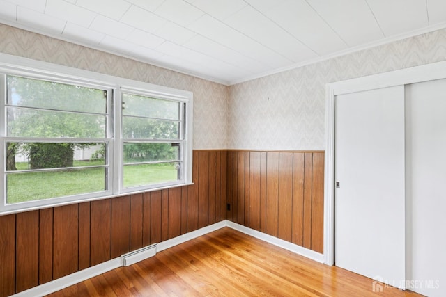 192 Lakeview Ave, Piscataway, NJ 08854 - unfurnished room featuring a baseboard heating unit, wood finished floors, crown molding, wainscoting, and wallpapered walls
