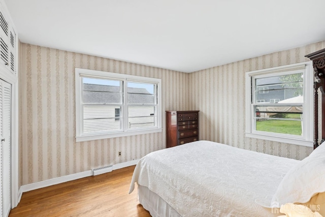 192 Lakeview Ave, Piscataway, NJ 08854 - bedroom featuring wood finished floors, wallpapered walls, a closet, and a baseboard heating unit