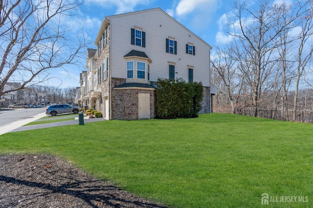 view of front facade featuring a front yard and stone siding