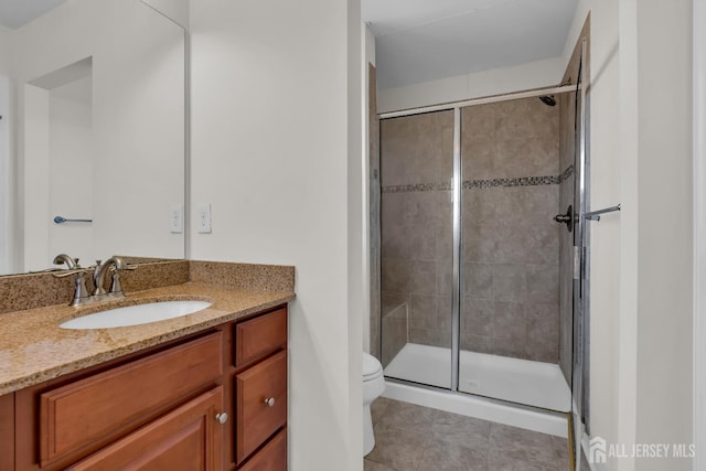 full bath featuring tile patterned flooring, a stall shower, toilet, and vanity