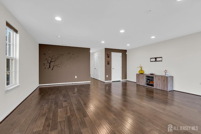 unfurnished living room with recessed lighting, wood finished floors, and baseboards