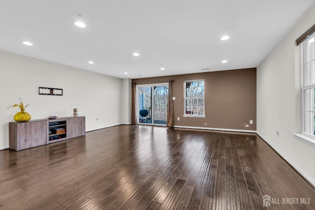 unfurnished living room with recessed lighting, baseboards, and wood finished floors