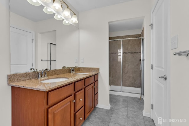 bathroom with a shower stall, double vanity, tile patterned floors, and a sink