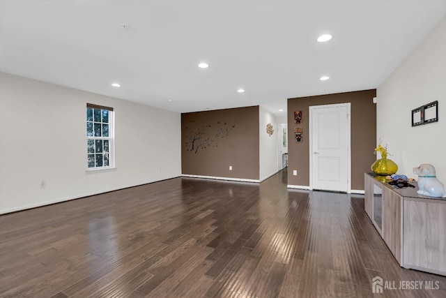 unfurnished living room with recessed lighting, baseboards, and dark wood-style floors