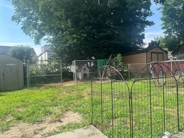 view of yard featuring a storage shed, an outdoor structure, and a fenced backyard