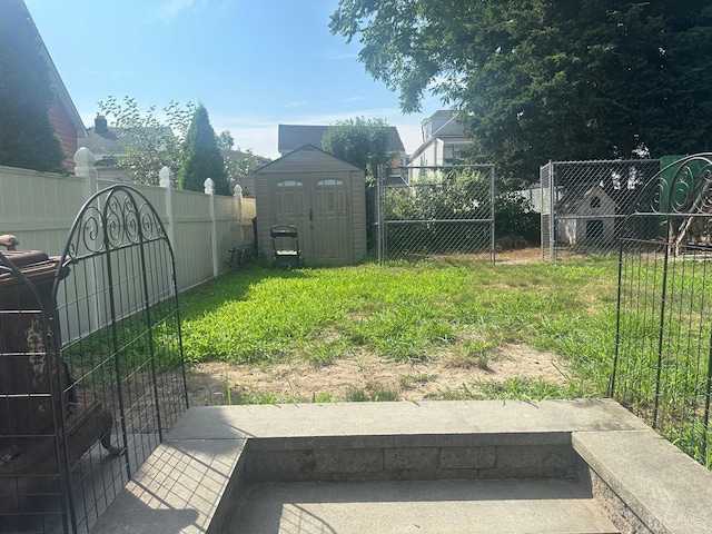 view of yard featuring an outbuilding, a shed, and a fenced backyard