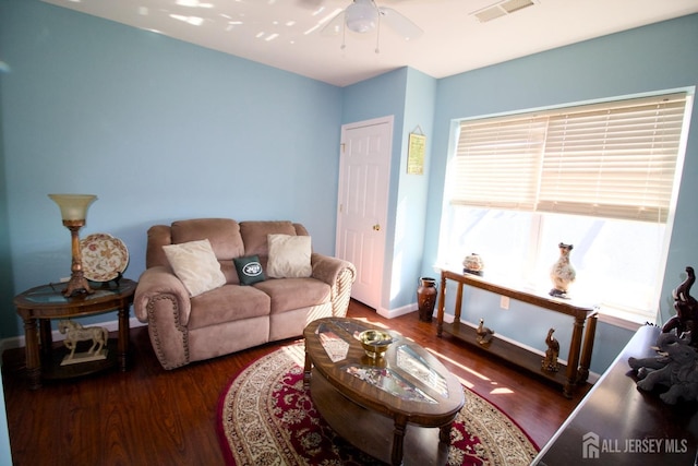 living room featuring a ceiling fan, baseboards, visible vents, and wood finished floors