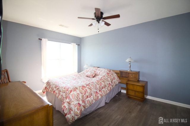 bedroom featuring a ceiling fan, visible vents, wood finished floors, and baseboards