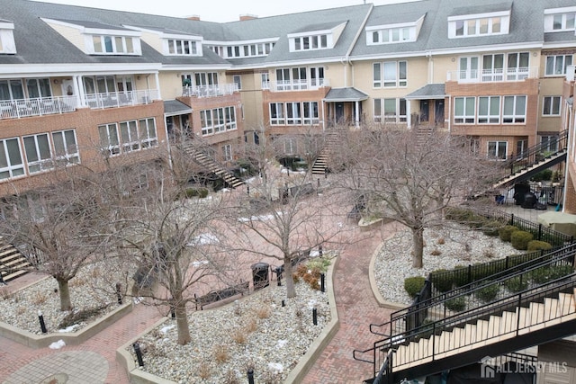 view of property's community with fence and stairs