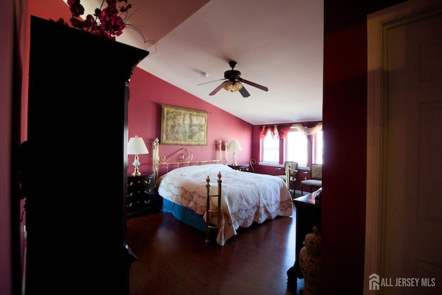 bedroom with ceiling fan, wood finished floors, and vaulted ceiling