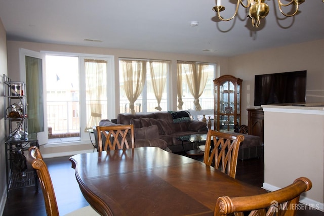 dining room with baseboards, dark wood-type flooring, and a chandelier