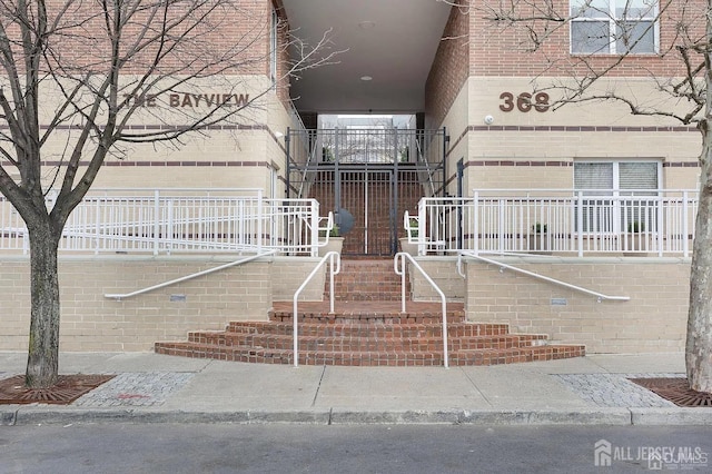 view of exterior entry with brick siding and covered porch