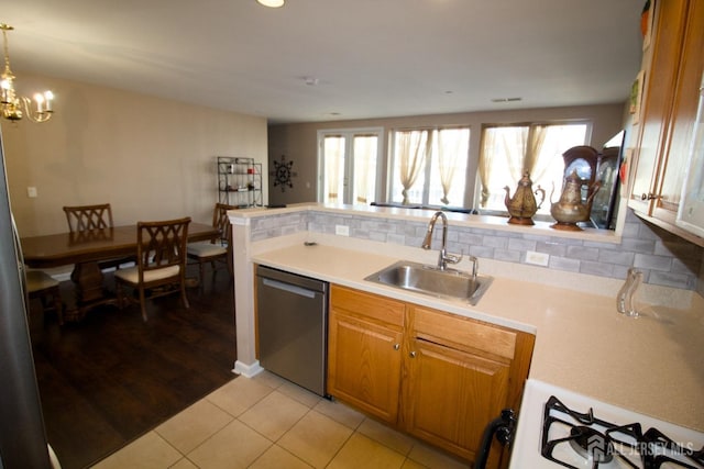 kitchen with light countertops, decorative backsplash, stainless steel dishwasher, light tile patterned flooring, and a sink