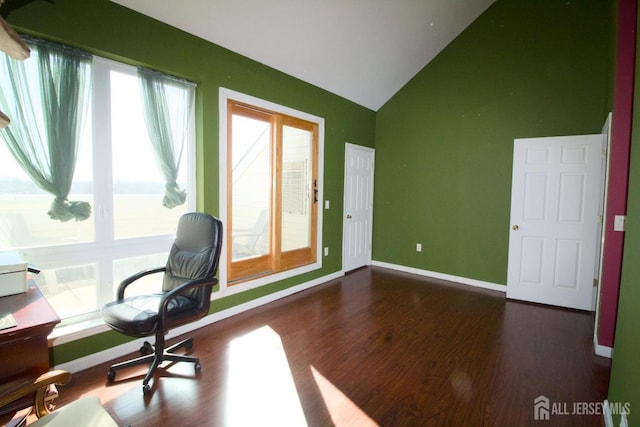 unfurnished office featuring dark wood finished floors, high vaulted ceiling, and baseboards